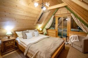 1 dormitorio con 1 cama en una cabaña de madera en Willa i Domki Pod Reglami, en Zakopane