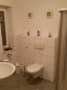 a white bathroom with a toilet and a sink at Nordseeholiday in Nordhastedt