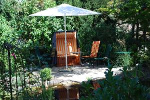 eine Terrasse mit einem Tisch, einem Sonnenschirm und 2 Stühlen in der Unterkunft Ferienwohnungen an der Kaiserpfalz in Goslar