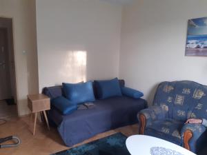 sala de estar con sofá azul y silla en Mieszkanie 2-pokojowe, en Rzeszów