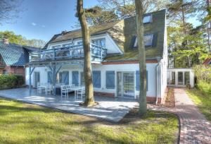 a house with a deck and a patio at Strandhafer in Boltenhagen