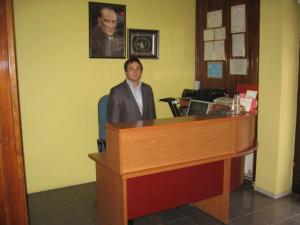 a man sitting at a desk in a office at Hotel Atasayan in Gebze
