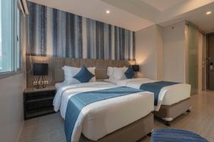 um quarto de hotel com duas camas e uma janela em Bayfront Hotel Cebu Capitol Site em Cebu