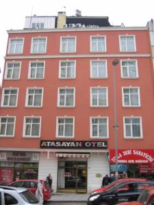 a red building on a street with cars parked in front at Hotel Atasayan in Gebze