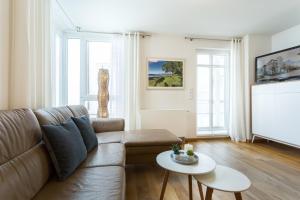 uma sala de estar com um sofá e uma televisão em Seemöwe - Villa Helene mit Meerblick in Top Lage em Binz