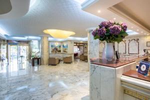 eine Lobby mit einer Vase Blumen auf dem Tresen in der Unterkunft Hôtel Belvédère Fourati in Tunis