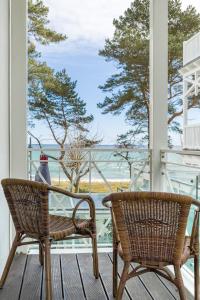 eine Veranda mit 2 Stühlen und einem Tisch sowie Meerblick in der Unterkunft Seemöwe - Villa Helene mit Meerblick in Top Lage in Binz