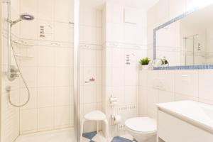ein weißes Badezimmer mit Dusche und Toilette in der Unterkunft Seemöwe - Villa Helene mit Meerblick in Top Lage in Binz + 12 Fotos