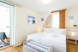 ein weißes Schlafzimmer mit einem Bett und einem Fenster in der Unterkunft Seemöwe - Villa Helene mit Meerblick in Top Lage in Binz