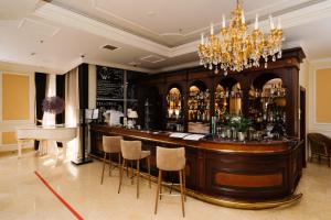 un bar in una stanza con lampadario a braccio di Grand Hotel Emerald a San Pietroburgo