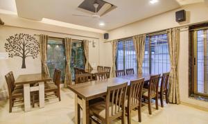 - une salle à manger avec une table, des chaises et des fenêtres dans l'établissement Treebo Trend Sumati Baner, à Méribel Village