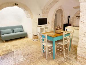 um quarto com uma mesa e cadeiras e um sofá em Trullo Bianco Ostuni em Ostuni