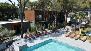 a swimming pool with chairs and a house at Unique Life Style Hotel in Kuşadası