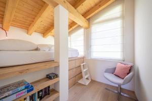 een kleine slaapkamer met een bed en een stoel bij COCOON - Laax in Laax