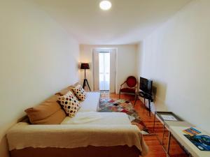 ein Wohnzimmer mit einem Sofa und einem TV in der Unterkunft Bairro Alto Studios & Flats by Lisbon Village Apartments in Lissabon
