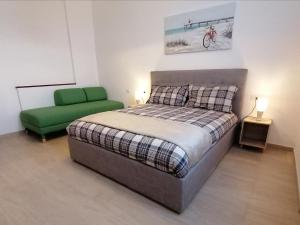sypialnia z łóżkiem i zielonym krzesłem w obiekcie San Bartolo Rent Apartments, un passo da Firenze w mieście Trespiano