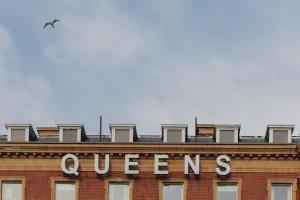 um edifício com uma placa no topo em The Queens Hotel em Portsmouth