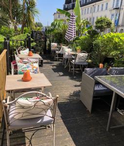 a row of tables and chairs with tables and chairs at Southbank TOWN HOUSE in Torquay