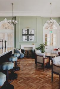 a lobby with tables and chairs and a fireplace at The Queens Hotel in Portsmouth