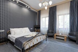 a bedroom with a bed and two chairs at Illés Hotel in Szeged +103 photos