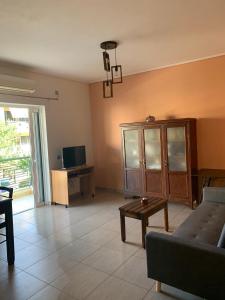 a living room with a couch and a tv and a table at SANTA MAURA in Lefkada Town