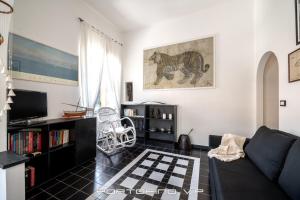 - un salon avec un canapé et une étagère à livres dans l'établissement Angolo di mare by PortofinoVip, à Portofino