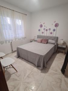 sypialnia z dużym łóżkiem z kwiatami na ścianie w obiekcie A Casa de Carmen w mieście Frije