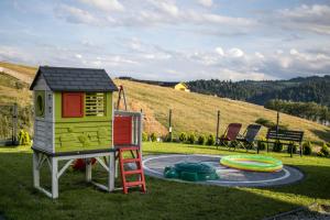a play area with a play house and a playground at OSADA Rokicie in Kluszkowce