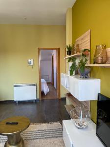a living room with yellow walls and a table at Mirador Islas de Arousa in Ribeira +53 photos
