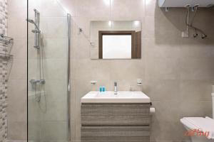 un bagno con lavandino e doccia in vetro di Luxurious Duplex Seafront Apt w Amazing Sea Views a Birżebbuġa