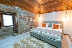 ein Schlafzimmer mit einem Bett in einer Steinmauer in der Unterkunft Casas da Fonte - Turismo Rural in Vila Verde