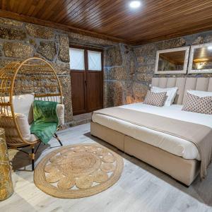ein Schlafzimmer mit 2 Betten und einem Rattanstuhl in der Unterkunft Casas da Fonte - Turismo Rural in Vila Verde