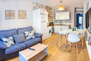 a living room with a blue couch and a kitchen at A - Apartamento elegante con piscina compartida in Torrico