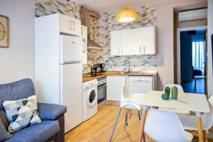 a small kitchen with a white refrigerator and a table at A - Apartamento elegante con piscina compartida in Torrico