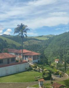 - Vistas a una casa con una palmera en Pousada Pedacinho do Céu -Chalé Familia, en Cunha