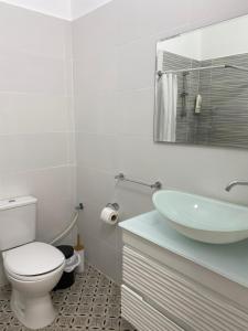 a white bathroom with a toilet and a sink at Laila's studio2 in Haifa
