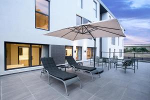 un patio con mesa, sillas y sombrilla en Nordic Hotel Lagos, en Lagos