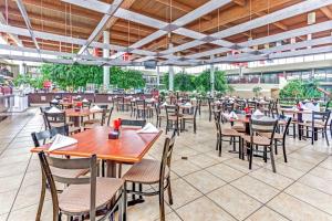 ロムルスにあるウィンダム ガーデン デトロイト メトロ エアポートのテーブルと椅子が置かれた空きレストランです。