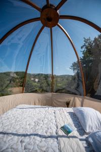 a bed in a tent with a large window at Rtanj hotel sa 1000 zvezdica 2 in Vrmdža