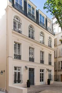 a large white building with windows and a door at Timhotel Opéra Blanche Fontaine in Paris
