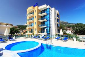 a hotel with a swimming pool in front of a building at Atlantic sobe in Dobra Voda