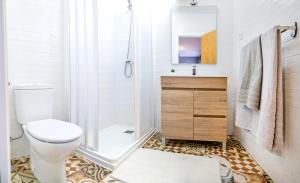 y baño blanco con aseo y ducha. en C - Apartamento moderno con piscina compartida, en Torrico