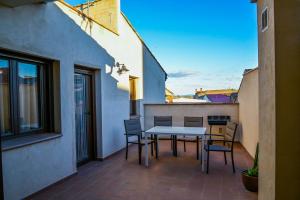 un patio con tavolo e sedie su un balcone di C - Apartamento moderno con piscina compartida a Torrico