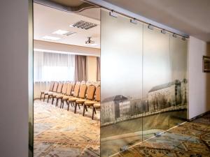 a conference room with chairs and a glass wall at IBIS Styles Kaunas Centre in Kaunas