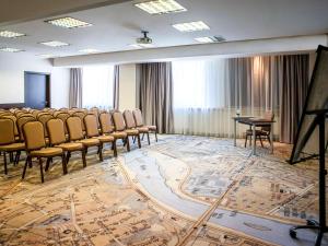 a conference room with chairs and a table and a podium at IBIS Styles Kaunas Centre in Kaunas