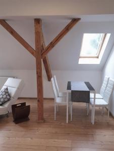 a dining room with a table and white chairs at Vogelnest Riesa in Riesa