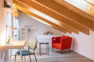an attic office with a red chair and a desk at ALTIDO Contemporary apartments in historical Giambellino-Lorenteggio in Milan