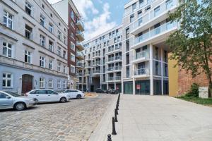brukowana ulica z samochodami zaparkowanymi przed budynkami w obiekcie Apartments Wrocław Jana Pawła II with FREE PARKING Wrocław by Noclegi Renters we Wrocławiu