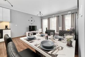 kuchnia i jadalnia ze stołem i krzesłami w obiekcie Apartments Wrocław Jana Pawła II with FREE PARKING Wrocław by Noclegi Renters we Wrocławiu