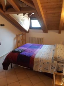 een slaapkamer met een bed met een kleurrijke deken bij Casa Cheney in Saint-Christophe